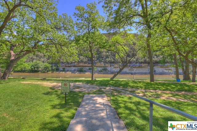 view of home's community with a water view and a yard