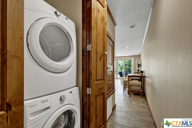 clothes washing area featuring ornamental molding and stacked washer and clothes dryer