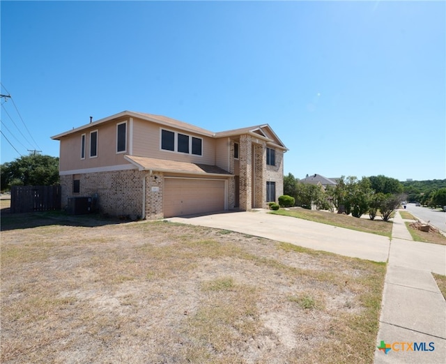 view of front of house with a garage, central AC, and a front yard