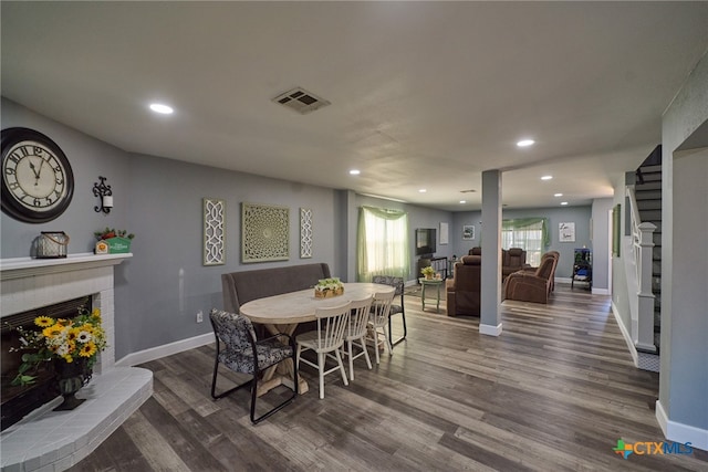 dining area with a brick fireplace and hardwood / wood-style floors