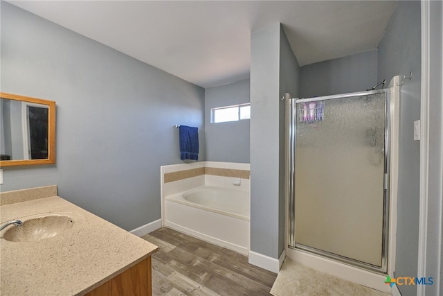 bathroom with plus walk in shower, vanity, and wood-type flooring