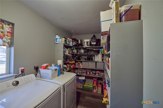 clothes washing area with washing machine and dryer and dark hardwood / wood-style floors