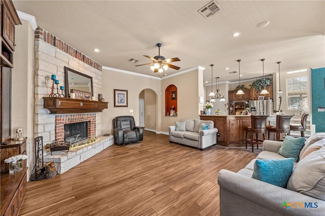 924 Queen Elizabeth Dr, Mcgregor, TX 76657 - living room featuring visible vents, arched walkways, wood finished floors, and crown molding