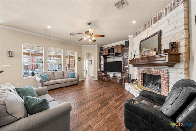 924 Queen Elizabeth Dr, Mcgregor, TX 76657 - living room featuring visible vents, a brick fireplace, ceiling fan, arched walkways, and dark wood-style flooring