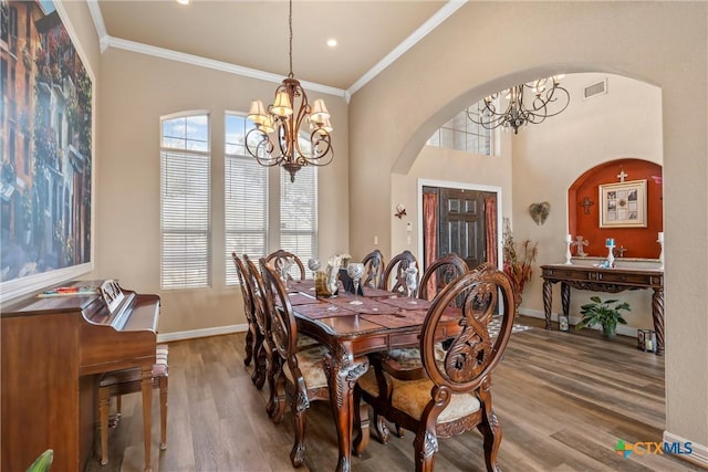 924 Queen Elizabeth Dr, Mcgregor, TX 76657 - dining space featuring wood finished floors, arched walkways, a chandelier, and crown molding