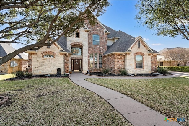 924 Queen Elizabeth Dr, Mcgregor, TX 76657 - french country home featuring a front lawn, brick siding, stone siding, and a shingled roof