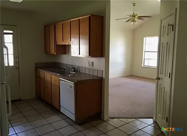 kitchen with light carpet, sink, dishwasher, lofted ceiling, and ceiling fan