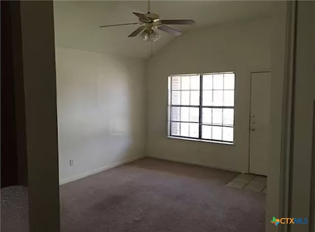 spare room featuring dark colored carpet, lofted ceiling, and ceiling fan