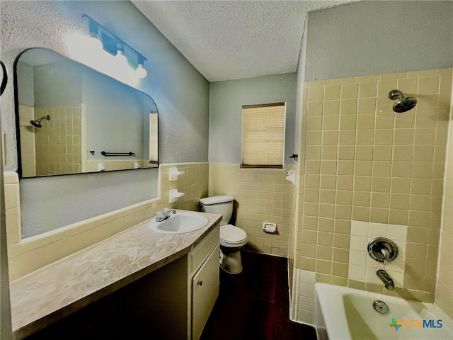 917 Edwards St, Copperas Cove, TX 76522 - bathroom with a textured ceiling, tile walls, shower / bath combination, vanity, and wainscoting