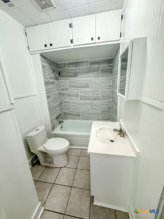 full bathroom featuring tile patterned flooring, vanity, toilet, and tiled shower / bath