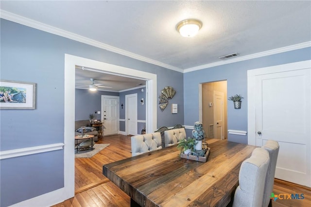 dining space with hardwood / wood-style floors, ceiling fan, and ornamental molding