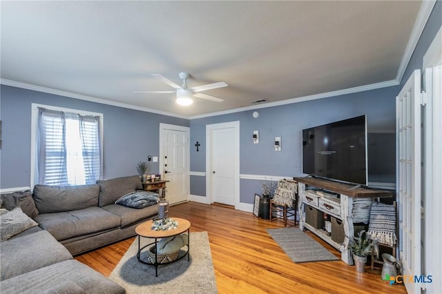 living room with light hardwood / wood-style flooring, ceiling fan, and crown molding