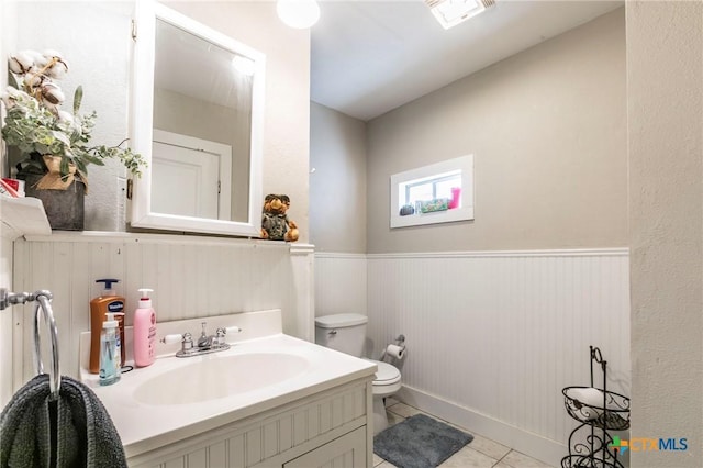 bathroom with tile patterned flooring, vanity, and toilet