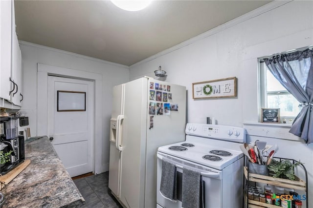 kitchen with white appliances, dark tile patterned flooring, and crown molding