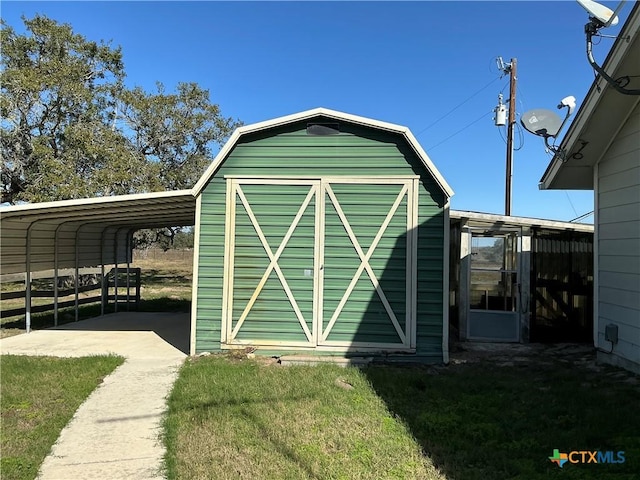 view of outbuilding featuring a carport and a lawn