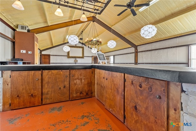 kitchen with hanging light fixtures, ceiling fan with notable chandelier, concrete floors, and vaulted ceiling