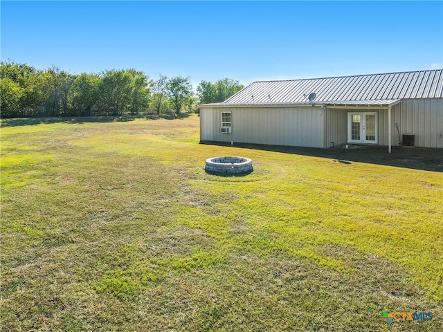 view of yard featuring french doors and an outdoor fire pit