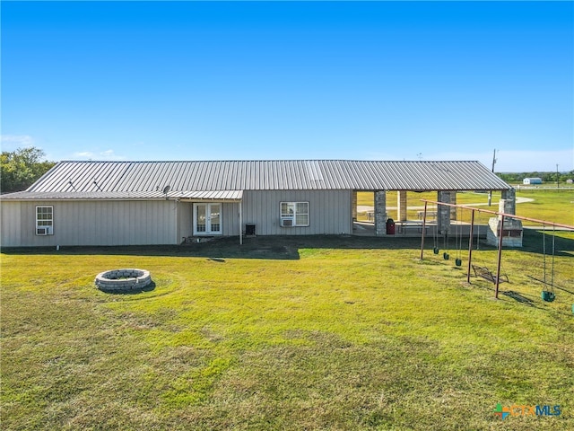 back of house with a yard and an outdoor fire pit