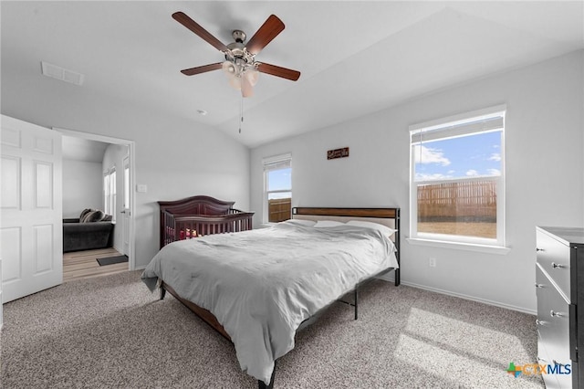 carpeted bedroom with ceiling fan, visible vents, baseboards, and vaulted ceiling