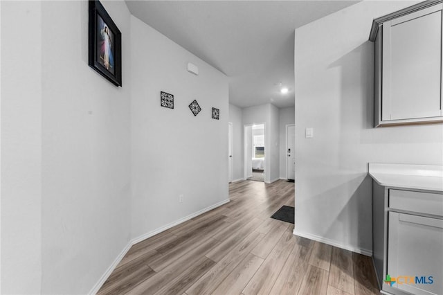 hall featuring baseboards and light wood-style floors