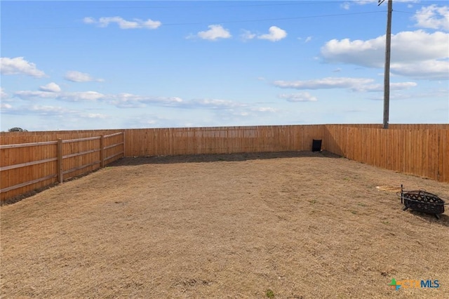 view of yard with an outdoor fire pit and a fenced backyard