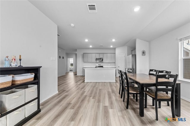 dining space featuring light wood-style floors, recessed lighting, visible vents, and baseboards