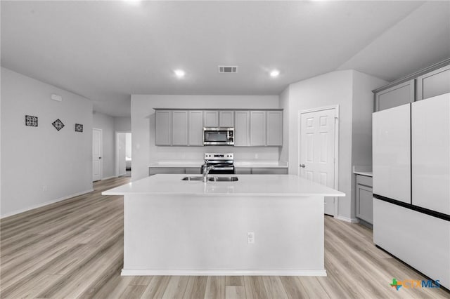 kitchen featuring stainless steel appliances, light countertops, gray cabinets, and visible vents