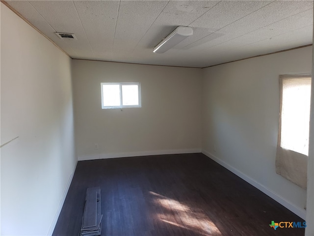 unfurnished room with dark hardwood / wood-style flooring