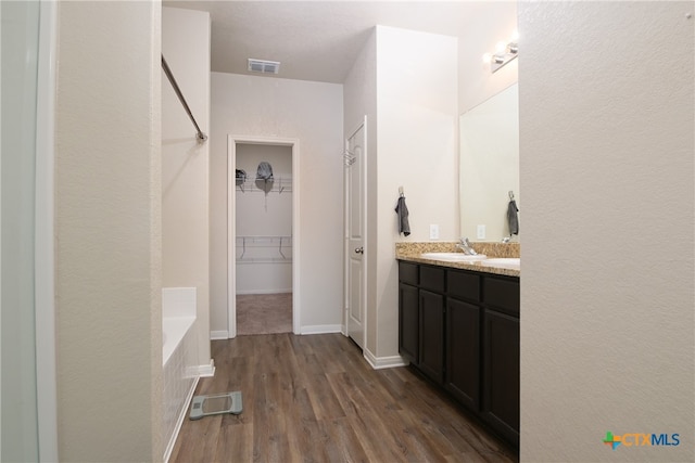 bathroom featuring a bath, hardwood / wood-style flooring, and vanity