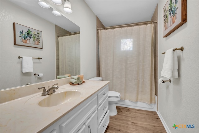 full bathroom featuring hardwood / wood-style flooring, vanity, toilet, and shower / bath combination with curtain