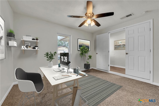 carpeted office space featuring ceiling fan