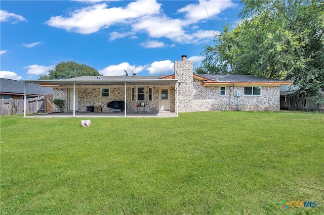 rear view of house with a patio and a yard