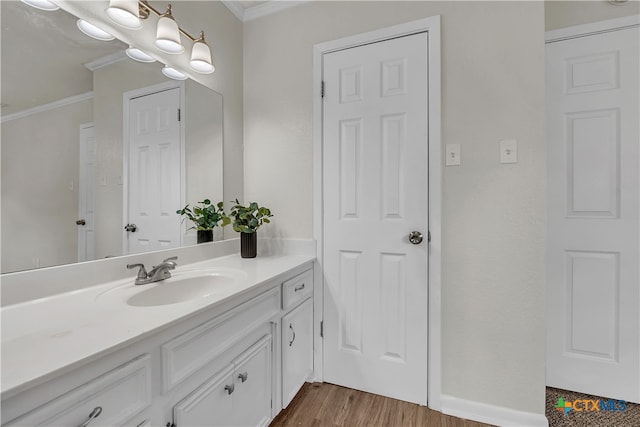 bathroom featuring ornamental molding, vanity, and hardwood / wood-style flooring