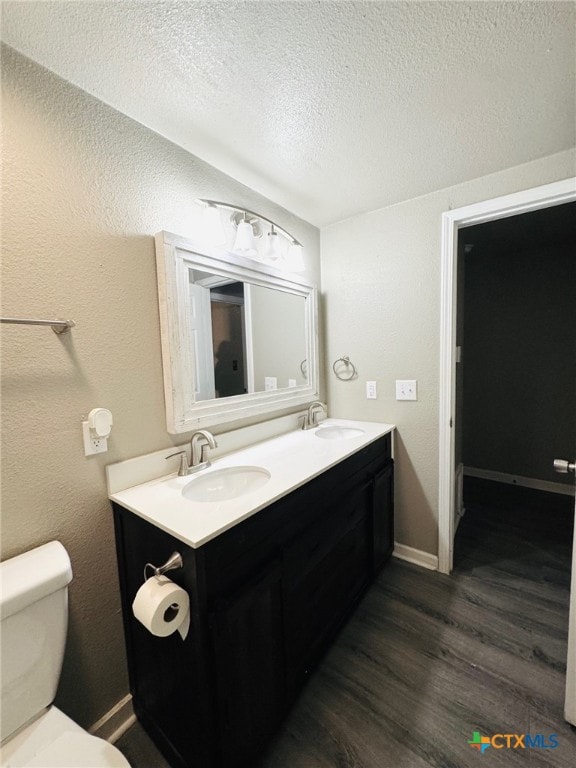 706 Golf Course Rd, Gatesville, TX 76528 - bathroom with double vanity, a sink, wood finished floors, and toilet