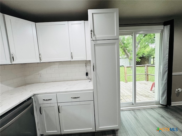 706 Golf Course Rd, Gatesville, TX 76528 - kitchen with backsplash, stainless steel dishwasher, light stone countertops, wood finished floors, and white cabinets