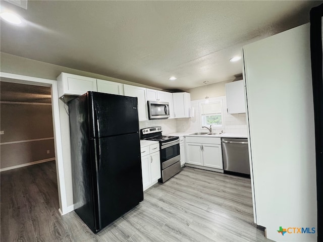 706 Golf Course Rd, Gatesville, TX 76528 - kitchen with white cabinets, a sink, light countertops, light wood-style flooring, and stainless steel appliances