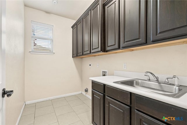 washroom featuring hookup for an electric dryer, hookup for a washing machine, cabinets, sink, and light tile patterned floors