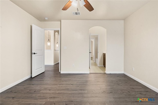 unfurnished bedroom with dark hardwood / wood-style floors, ceiling fan, and ensuite bath