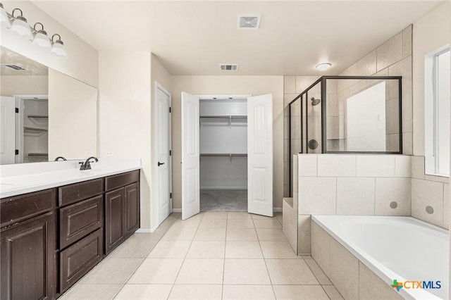 bathroom featuring tile patterned flooring, vanity, and separate shower and tub