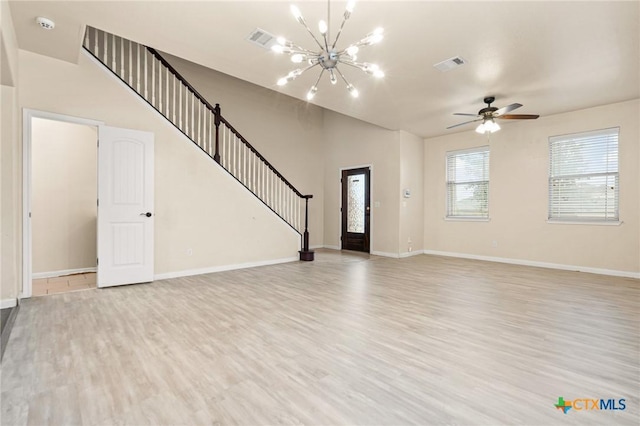 unfurnished living room with ceiling fan with notable chandelier and light wood-type flooring