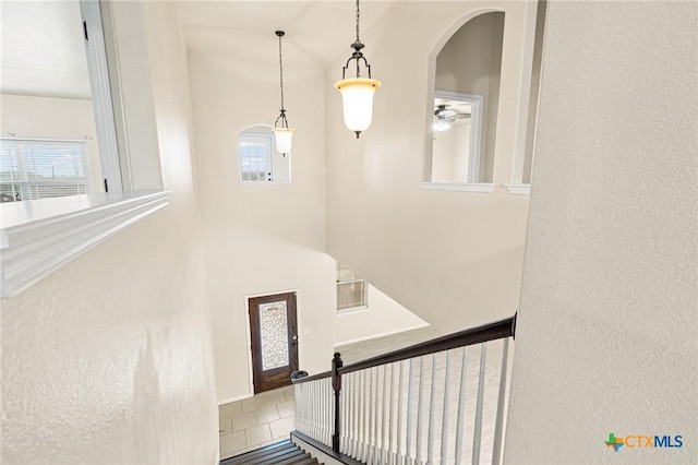 staircase featuring tile patterned floors and ceiling fan