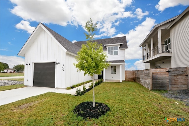 view of front facade featuring a garage, a front lawn, and a balcony