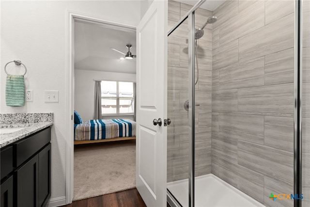 bathroom with walk in shower, vanity, hardwood / wood-style floors, lofted ceiling, and ceiling fan