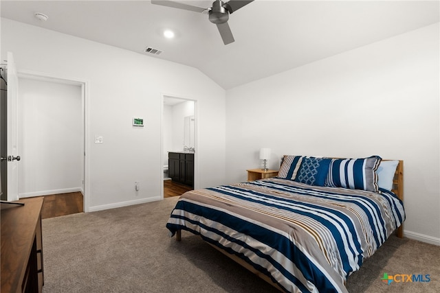 carpeted bedroom featuring ensuite bathroom, ceiling fan, and vaulted ceiling