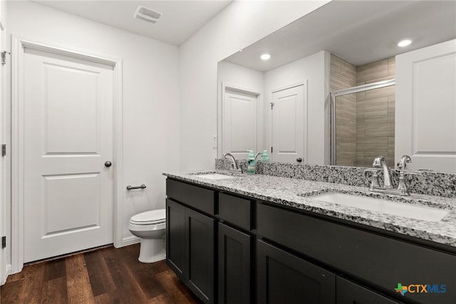 bathroom with hardwood / wood-style floors, an enclosed shower, vanity, and toilet