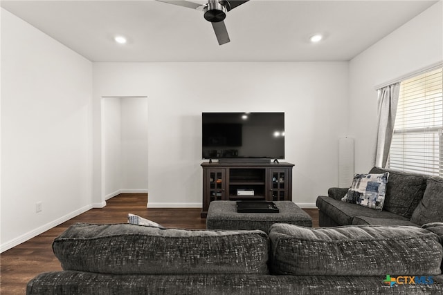 living room featuring dark wood-type flooring and ceiling fan