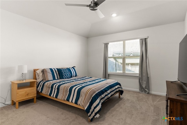 bedroom with vaulted ceiling, light colored carpet, and ceiling fan