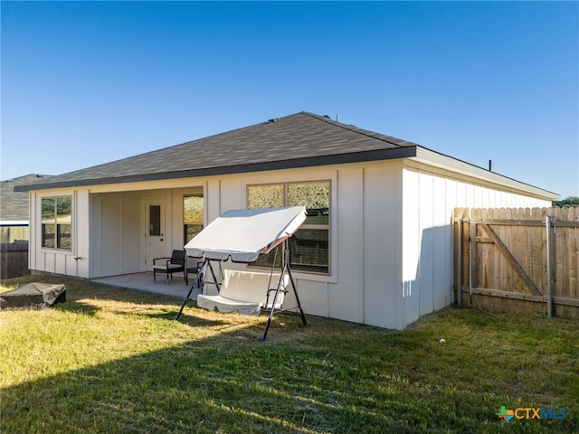 rear view of property featuring a patio and a yard