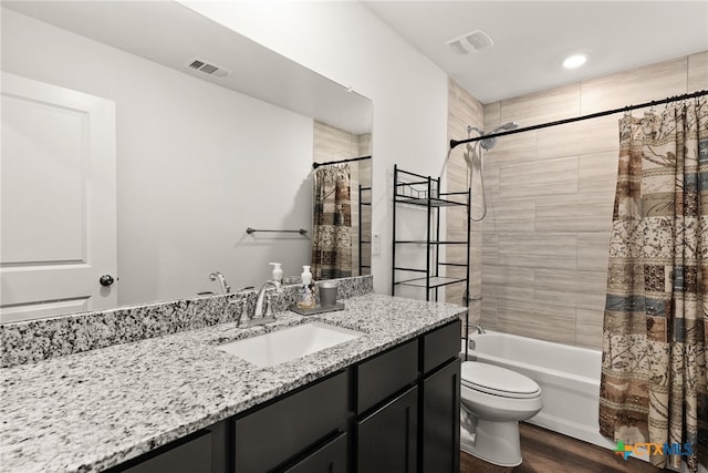 full bathroom with shower / tub combo with curtain, wood-type flooring, toilet, and vanity