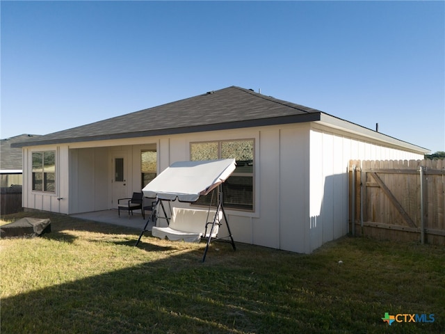 back of property featuring a patio and a yard